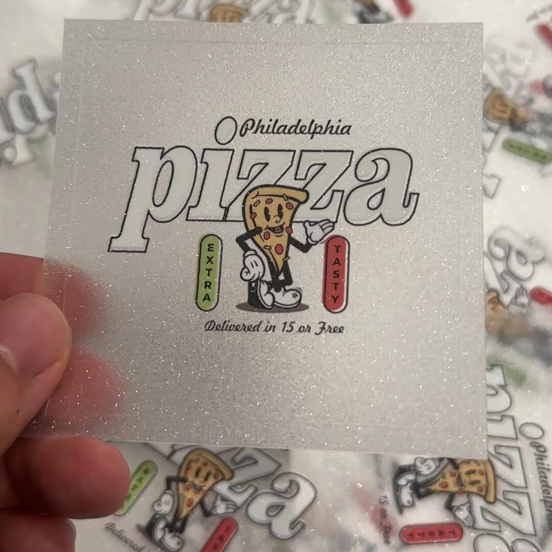Glittery sticker featuring a playful pizza slice design with text elements.