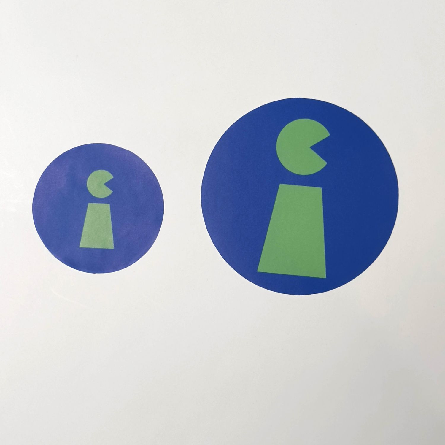 Two circular stickers with green and blue geometric designs on a white background.