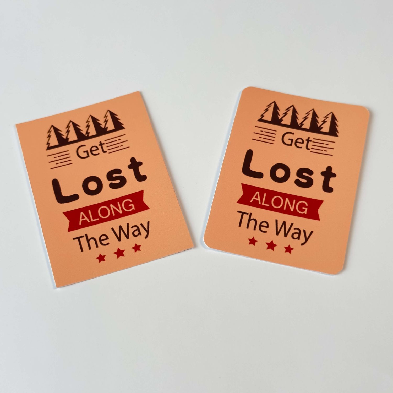 Two orange stickers with 'Get Lost Along The Way' text.